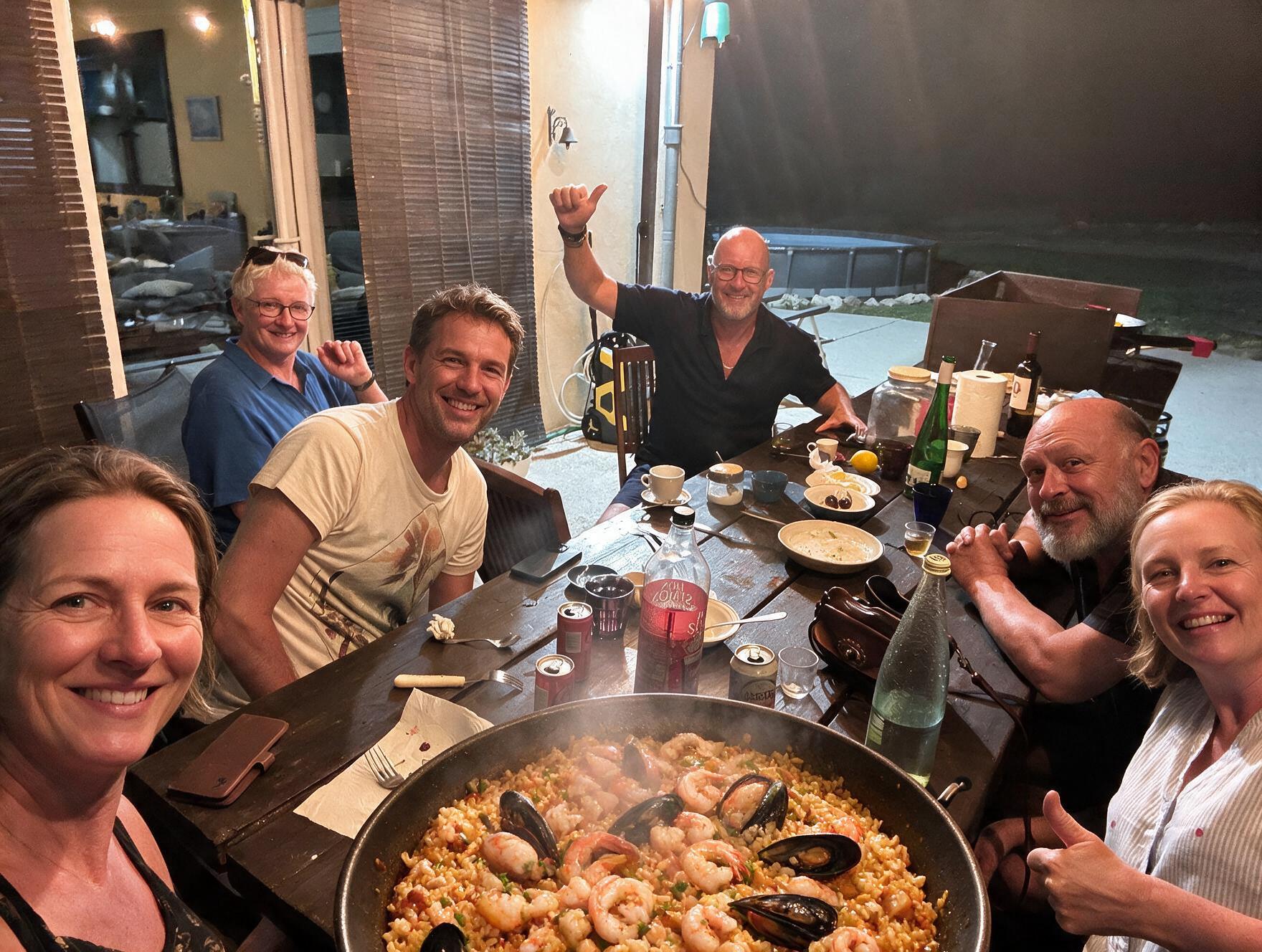 Grupo de campistas compartiendo una paella en la finca